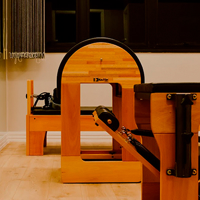 Equipamento Reformer em destaque na Sala 85 da unidade Aquarius, em ambiente aconchegante e bem iluminado.